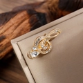 Detailed macro view of a vintage gold G-clef brooch with crystal inlay and teardrop gem - Gold & White Rhinestone Style (LZ015 Teardrop Gold & White)