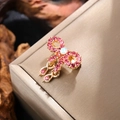 Close-up of pink rhinestone bow brooch with opal center on premium silk background - Gold with Pink Zirconia