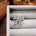 Détail macro d'une broche nœud argentée sertie de strass dans un coffret en velours - Argent Blanc