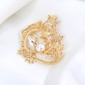Macro shot of gold dragon brooch with intricate hollow scales and white pearl detail - Coiled Golden Dragon