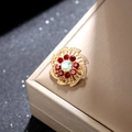 Detalle de broche de girasol dorado con cristales rojos y centro de estrás AB - Dorado / Rojo