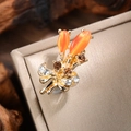 Detail of vintage tulip brooch with orange cat-eye stones and sparkling crystal accents - Gold-Orange