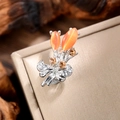 Macro shot of silver bouquet brooch with orange opals and crystal bow detailing - Silver-Orange