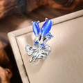 Macro detail of tulip flower brooch featuring blue cat eye stones and ribbon bow design - Silver-Blue