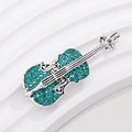 Elegant silver violin brooch with emerald green rhinestones on a white display pedestal - Silver Frame Green Rhinestone Violin