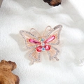 Detail van libelbroche in roségoud met roze kristallen en strass op een stenen achtergrond - Vlinder / Roze Vlinder (XZ5-275)