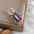 Nahaufnahme der Hirschkäfer-Brosche mit Emaille in Blau und Rot auf Altsilber - Blauer Und Roter Vintage Käfer