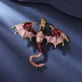 Vintage gold dragon brooch with purple enamel wings and ruby red teardrop crystals - Red Facing Dragon