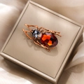 Detail of vintage beetle brooch with red faceted gemstone in a golden jewelry box - Red Beetle Style (XZ20-001)