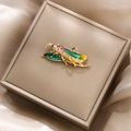 Detailed macro view of a vintage gold grasshopper brooch on a silk velvet jewelry box - Gold Grasshopper Leaf Style (XZ20-020)