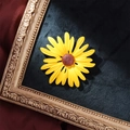 Elegant sunflower enamel brooch with yellow petals on a black velvet background - Yellow