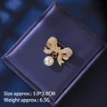 Detail einer Vintage-Schleifenbrosche mit Strass und Perlenanhänger auf einer Box - Gold Strass Schleife Stil (XZ24203)