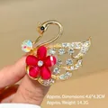 Detail of elegant swan brooch with crystals and red flower on golden alloy base - Red Swan