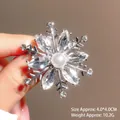 Close-up of silver snowflake brooch with sparkling crystals and a central pearl detail - Silver Base White Zirconia