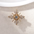 Macro shot of a vintage gold star brooch with crystal rhinestones on a stone surface - Vintage Cross Star Style (Special Offer 4)
