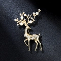 Dettaglio macro di un'elegante spilla a forma di alce dorata con perle e strass lucidi - Cervo Dorato