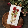 Detailaufnahme eines goldenen Rosenlesezeichens mit roter Quaste und Gravuren im Retro-Stil - Rosen-Stil (T01042302)