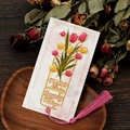 Detailansicht eines eleganten Tulpen-Metalllesezeichens mit Quaste auf dunklem Holz - Tulpen-Stil (T01042304)