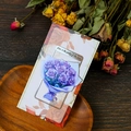Makroaufnahme von Blumen-Metall-Lesezeichen mit Gravur auf Vintage-Geschenkkarte - Lila Strauß Stil (T01042519)