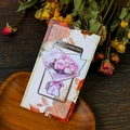 Nahaufnahme von Lesezeichen mit rosa Rosen auf dunklem rustikalem Holztisch - Rosa Strauß Stil (T01042518)