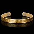 Classic 18K gold plated magnetic therapy bangle with Greek key pattern on black surface - Meander Magnet Style / Gold