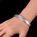Nahaufnahme des geprägten floralen Silbermusters auf dem antiken Kupferarmband für Damen - Silber