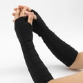 Detailed knit texture of long black fingerless gloves worn on arm for winter warmth - Black