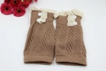 Close-up of knit leg warmer with lace trim, wood buttons, and hollow diagonal texture - Khaki
