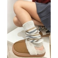 Detail of striped knitted leg warmers paired with plush faux fur slippers for winter - One Size / Beige