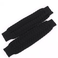 Detail van zwarte gebreide beenwarmers met golfpatroon, ribboorden en dikke textuur - Zwart