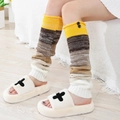 Women stripe knit leg warmers with buttons paired with plush open toe slippers on wood floor - One Size / Yellow
