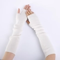 Close-up of white knitted cashmere fingerless gloves showing soft texture and arm coverage - White
