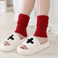 Short red knit leg warmers paired with white plush cross slippers on a wooden floor - Jujube Red