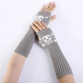 Detail of grey knitted arm warmer featuring white skull and crossbones graphic pattern - One Size / Light Gray