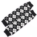 Close-up of black and white argyle knit leg warmers with elastic ribbed cuffs - Black + White
