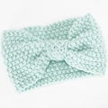 Detail der Strickstruktur eines minzgrünen Stirnbandes mit zentralem Knotendesign - See Blau
