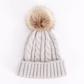 Close-up of thick cable knit texture and fluffy faux fur pompom on grey winter beanie - One Size / Light Gray