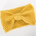 Detail of yellow knitted headband featuring chunky yarn texture and a center bow design - Yellow