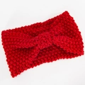 Makro-Detail von rotem Strickstirnband mit grober Webstruktur und Mittelknoten - Rot