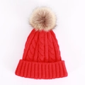 Detailed close-up of chunky cable knit texture and faux fur pompom on red winter beanie - One Size / Red
