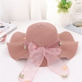 Detalle de sombrero de paja rosa con lazo de organza, flores 3D y perlas finas - Talla única / Malva