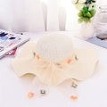 Detalle del sombrero de sol con lazo amarillo, flores y perlas sobre el tejido de paja - Talla única / Blanco