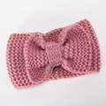 Dusty pink winter knitted headband for women featuring a large handmade bow decoration - Pink