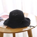Detail of black crochet sun hat with bow decoration on wooden table with accessories - One Size / Black