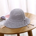 Detailed close-up of a light grey knitted sun hat featuring a delicate bow on a wooden surface - One Size / Light Gray
