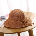 Detailed texture of brown crochet sun hat with hollow knit and bow on wooden table - One Size / Turmeric