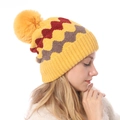 Detailed close-up of colorful wave pattern knit beanie with soft pom-pom decoration - One Size / Yellow