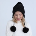 Close-up of black knit pom pom hat with three faux fur balls on a winter fashion model - Black