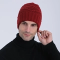 Close-up of deep red knitted beanie with diamond jacquard texture worn by male model - Red