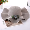 Elegant wavy wide brim straw hat in taupe with floral ribbon and leaf detail - One Size / Gray